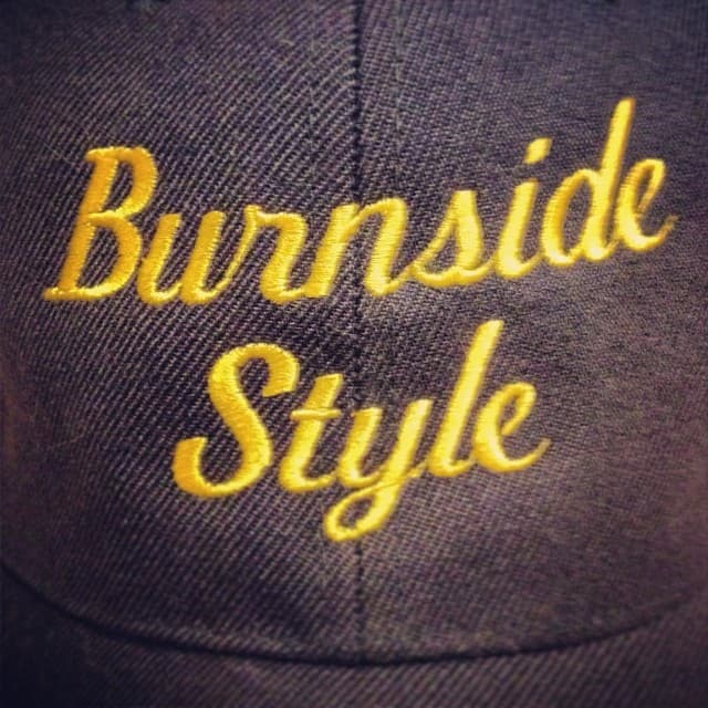 Dark blue hat with 'Burnside Style' embroidered on it in hand script type