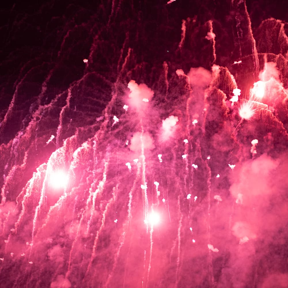 Red colored fireworks and smoke make a waterfall-esque texture