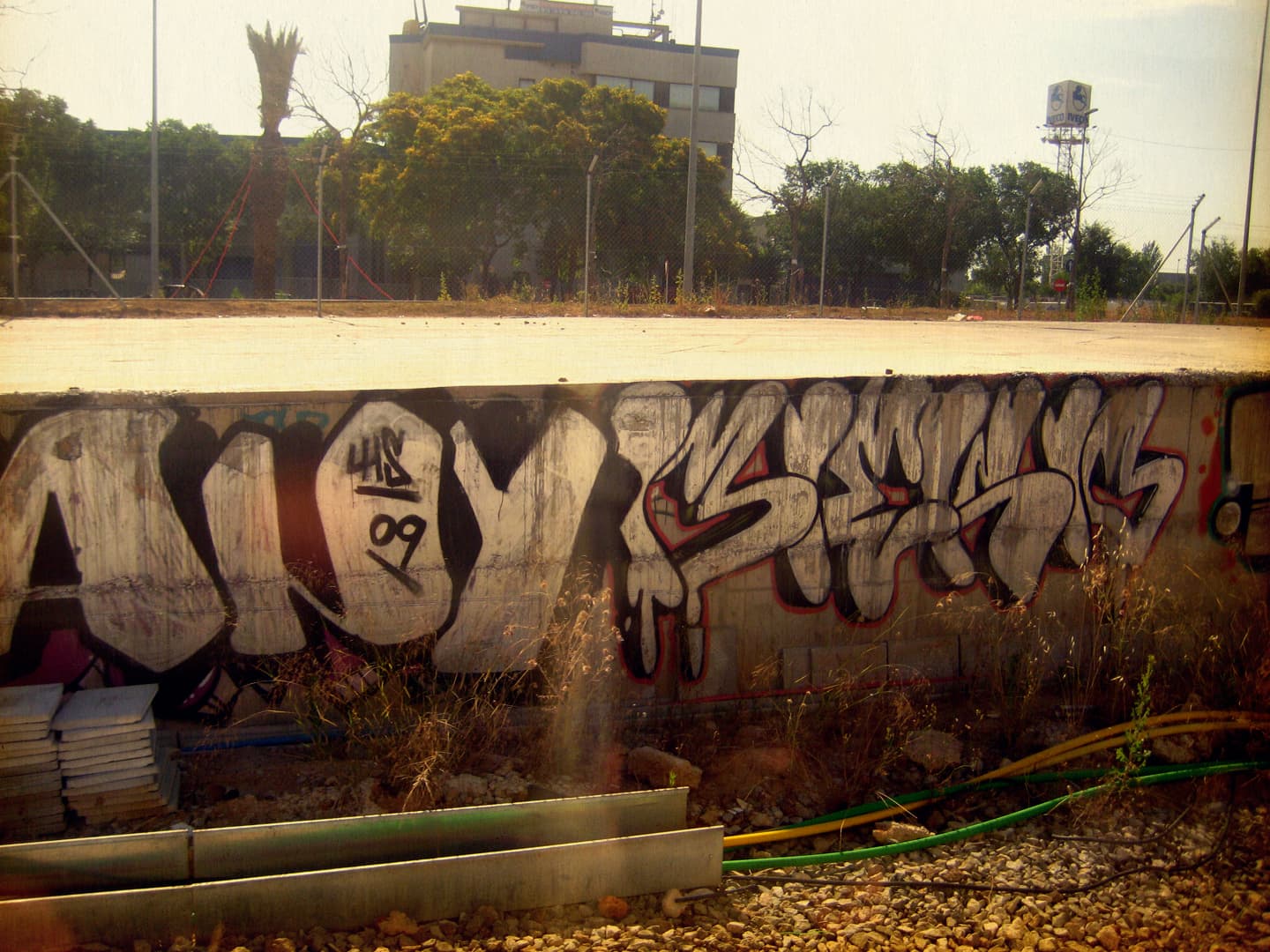 Graffiti tag on a wall surrounded by an urban landscape